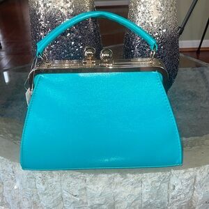 TURQUOISE WITH GOLD TRIM FITTED HANDBAG IS ALSO A CROSSBODY PURSE.